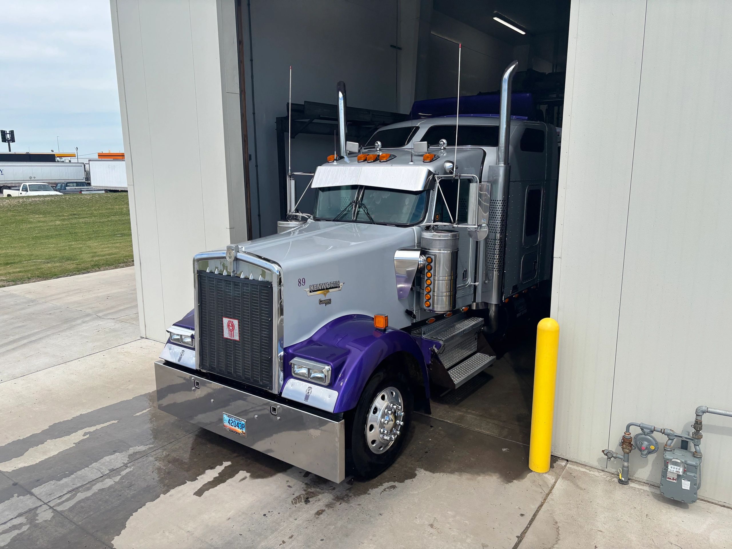 Purple Kenworth semi-truck in industrial garage